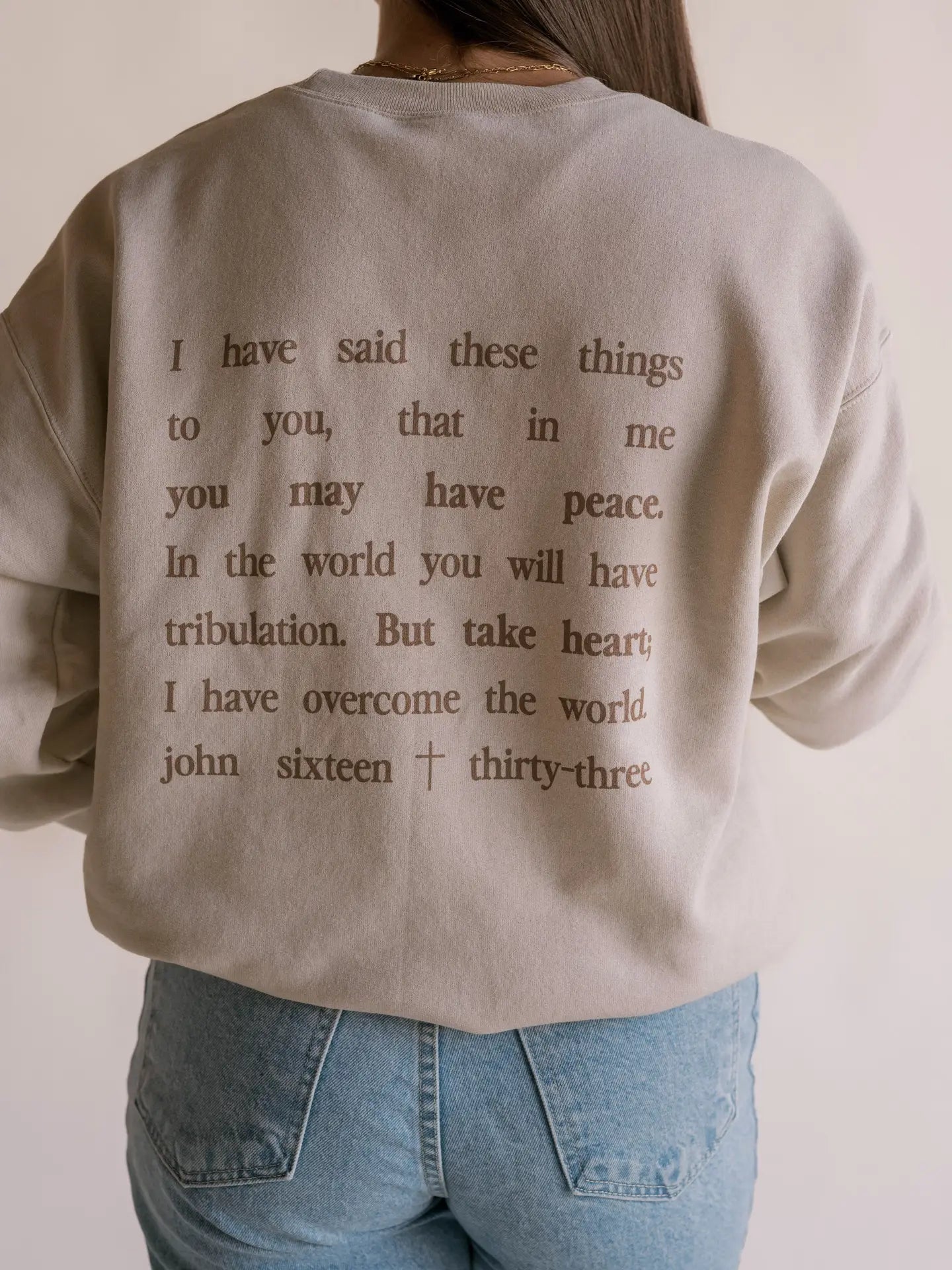 "i have said these things to you, that in me you may have peace. In the world you will have tribulation. But take heart i have overcome the world. john sixteen thirty-three" graphic crewneck sweatshrit BACK SIDE
